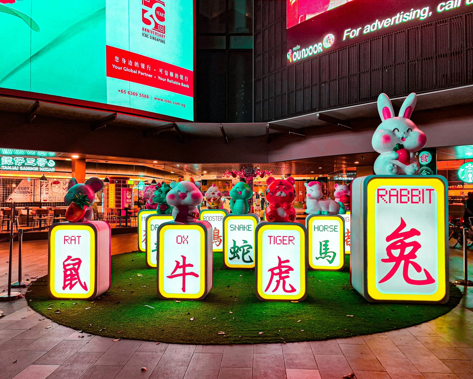 Colorful Chinese zodiac animal statues on illuminated blocks in a Singapore street display. Title: Chinese Zodiac Display Singapore