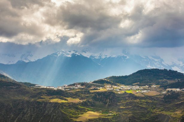 The sunlight punctured the thick clouds and fell on the Feilai Temple in front of the Meili Snow Mountain.
