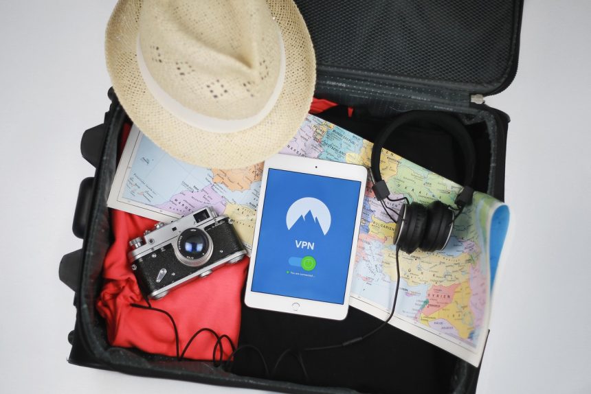Open suitcase with summer travel essentials including tablet showing VPN screen, map, camera, hat, and headphones for China trip.